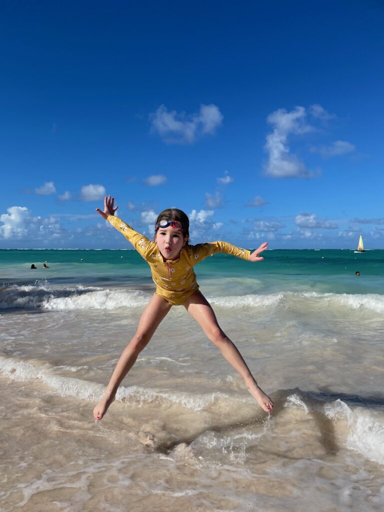 Girl jumping in the waves of the beach